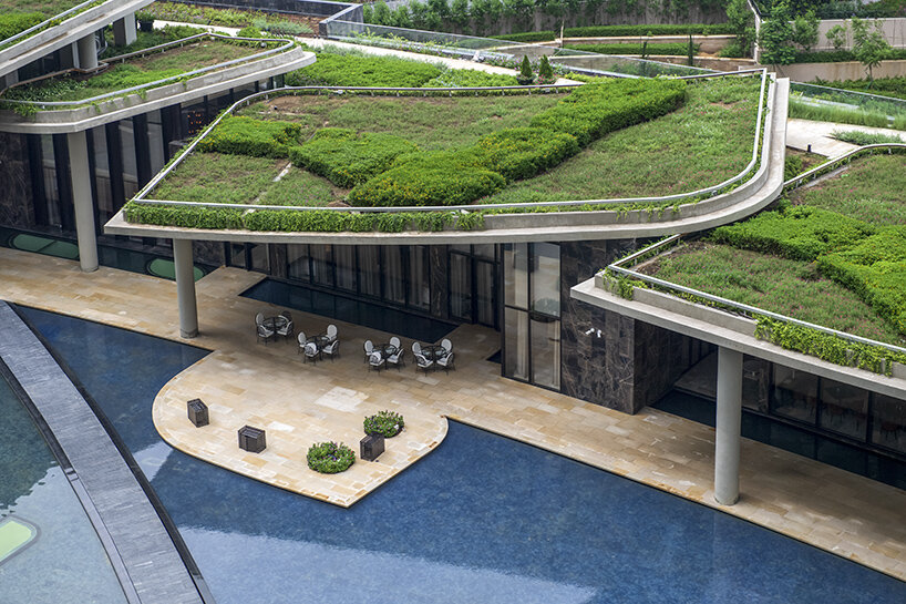 Green-roof clubhouse terraces beside the water garden